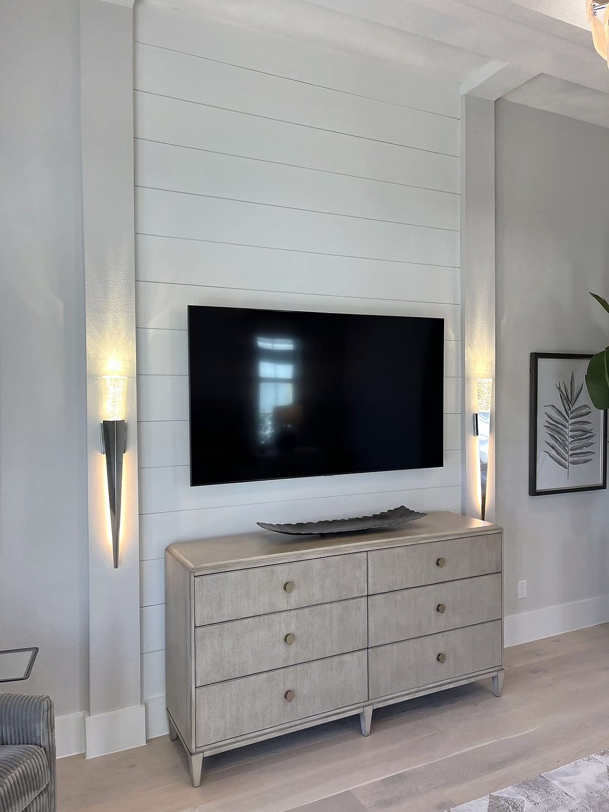 Shiplap TV wall with sconce lighting